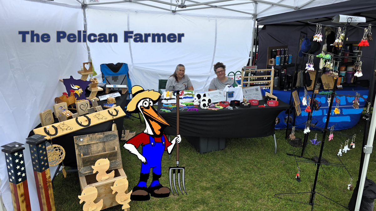 Outdoor event with 'The Pelican Farmer' booth displaying various items.